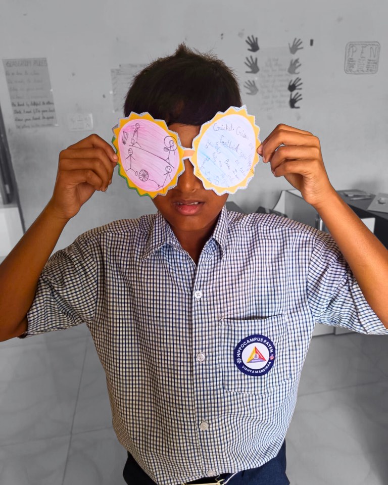 A Hippocampus student holding up paper glasses made in a Tilli activity